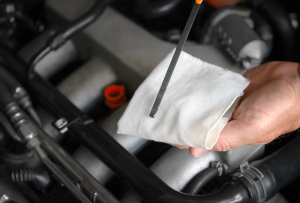 Service technician checking the oil with a white cloth. | Chevy service center in St. Louis, MO